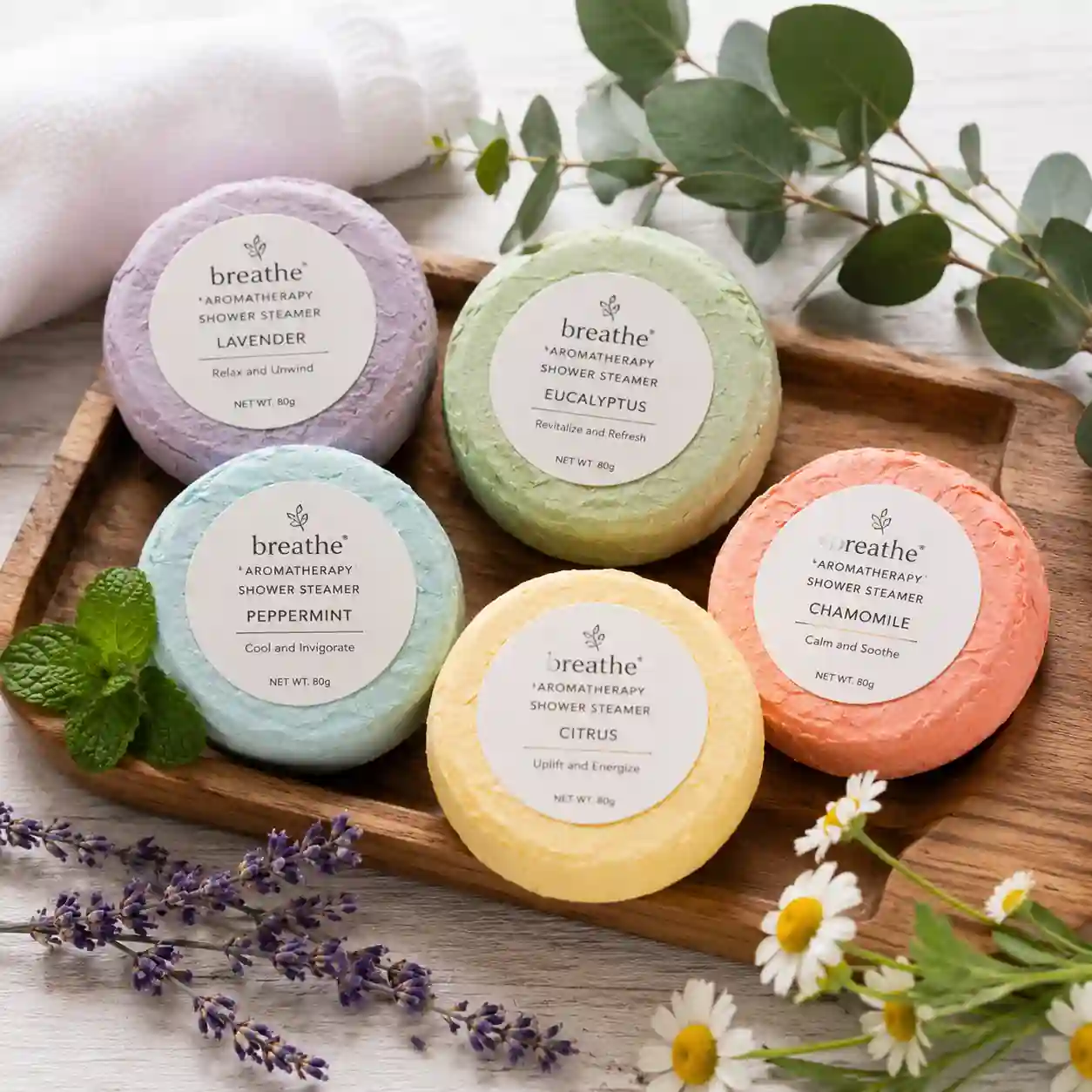 Aromatherapy shower steamers dissolving under water and releasing fragrant essential oil vapors